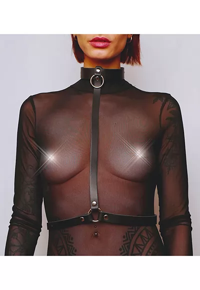 This black leather harness adorned with silver fasteners can be worn on its own or layered over clothing.  The clean lines of this harness lend it a particular elegance: this harness adorns the chest in a fetishistic style.  This bust harness consists of a collar that encircles the neck, then a strap that passes between the breasts and ends as a belt...