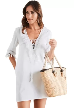 Robe de plage courte de la marque Selmark Mare, franges sur les manches, et le décolleté lacé.  Coloris blanc  1 pièce  Composition 56% coton, 44% lin