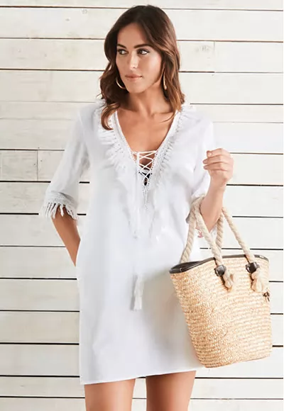 Robe de plage courte de la marque Selmark Mare, franges sur les manches, et le décolleté lacé.  Coloris blanc  1 pièce  Composition 56% coton, 44% lin